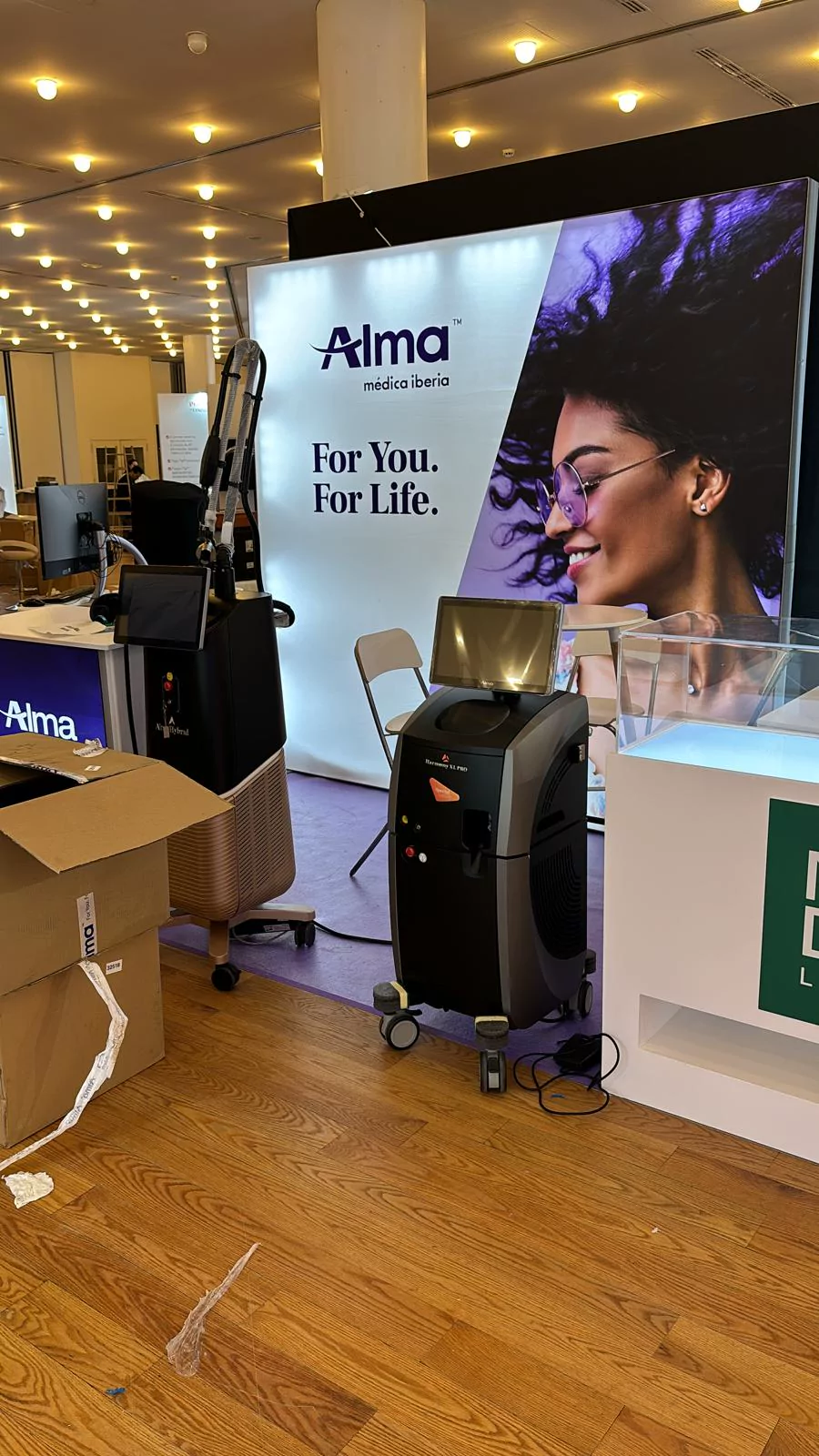 Stand de Alma Medical Iberia con gráfica iluminada y equipamiento médico