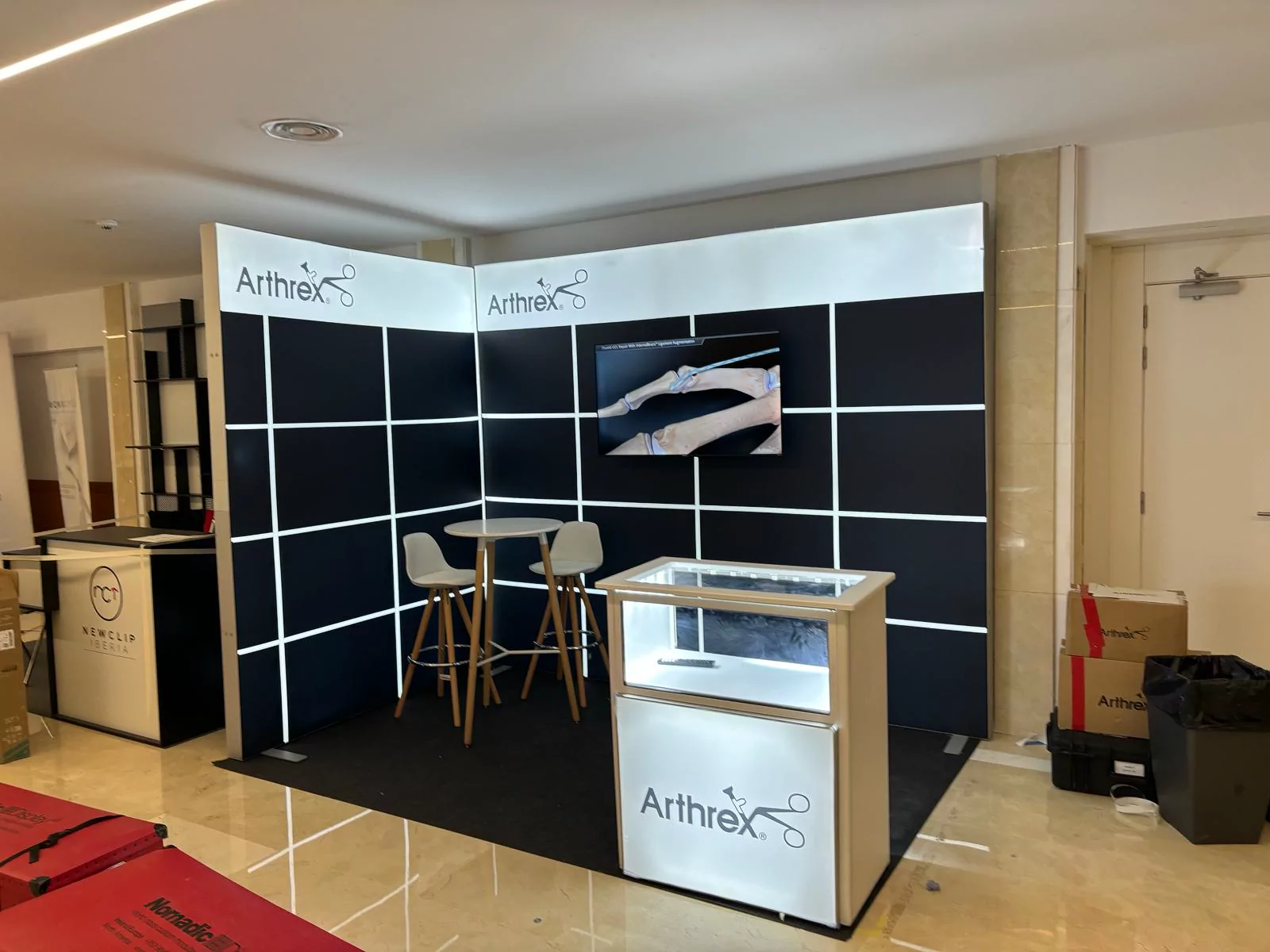 Stand de Arthrex con paredes modulares, pantalla y vitrinas iluminadas
