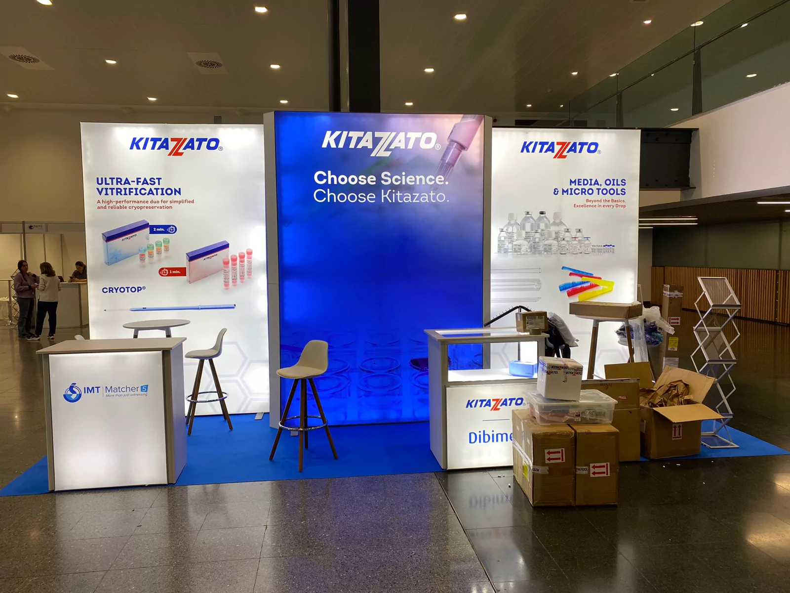 Stand de Kitazato con paneles retroiluminados azules y mostradores