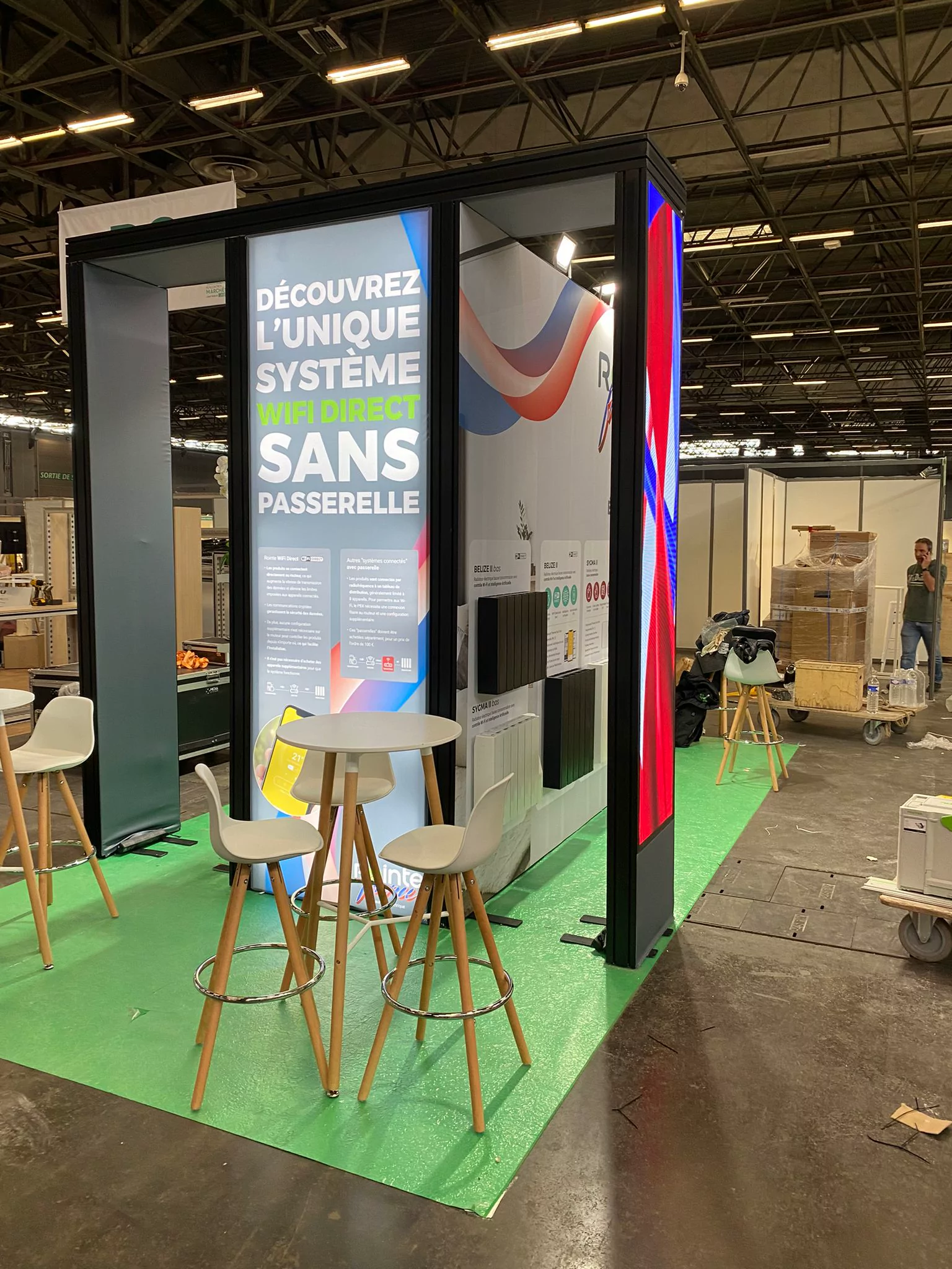 Stand de Rointe France con pantalla LED vertical y gráfica de producto
