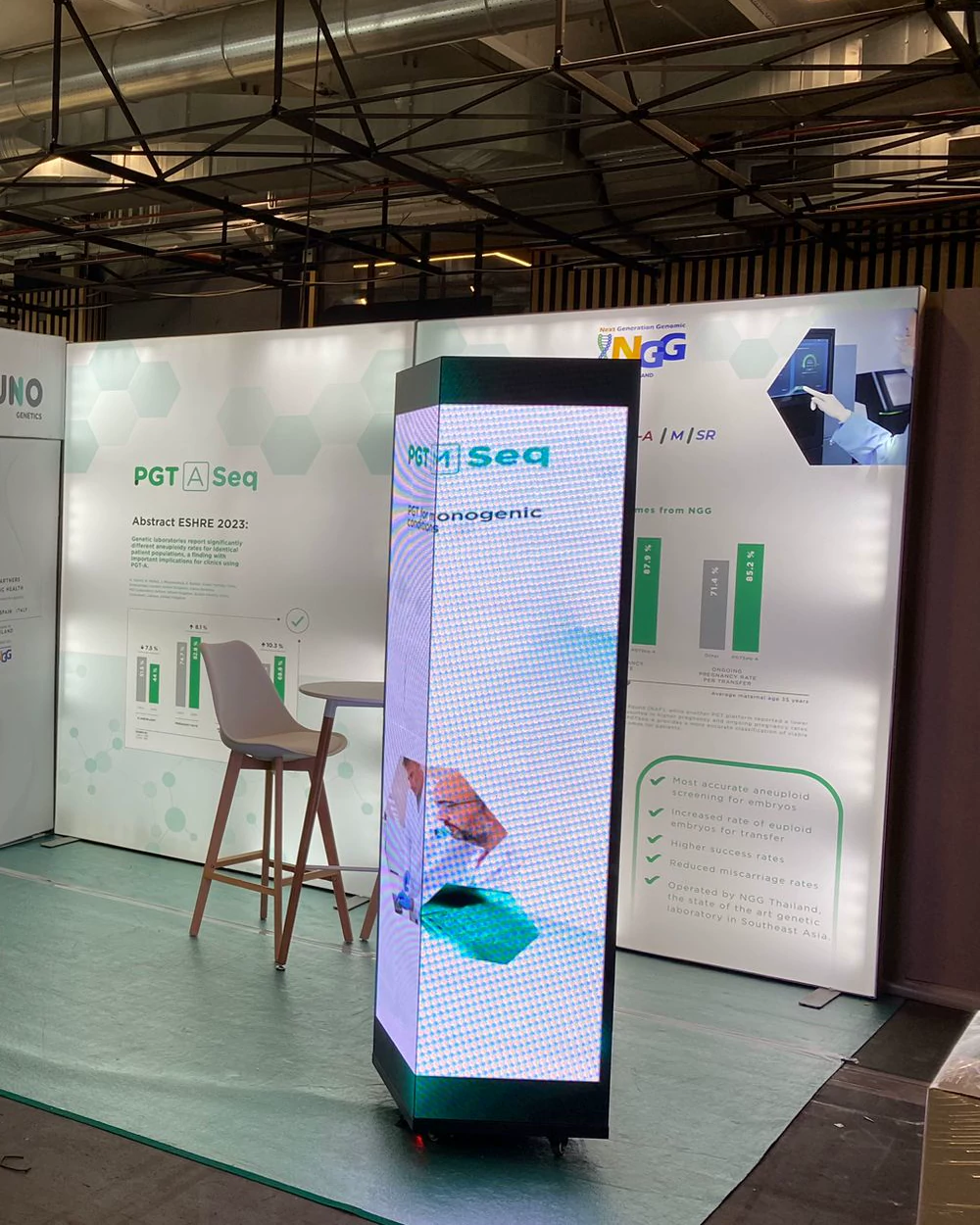 Stand de Juno Genetics con tótem LED vertical y mostradores iluminados